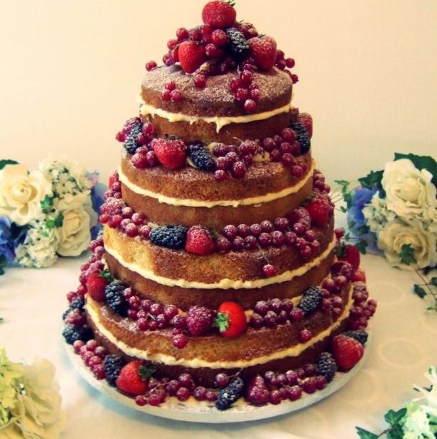 foto de um bolo naked de 4 andares com decorações de frutas vermelhas, exemplificando o trabalho feito por um doceiro profissional após concluir os cursos de gastronomia do iPED