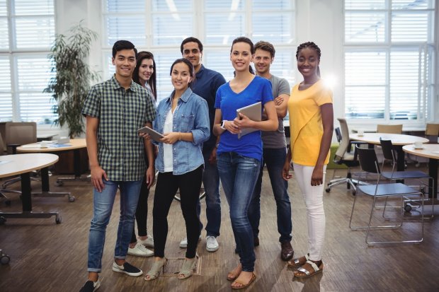 Colegas de trabalho reunidos numa sala com mesas e cadeiras