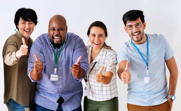 Colegas de trabalho sorrindo e com sinal de legal