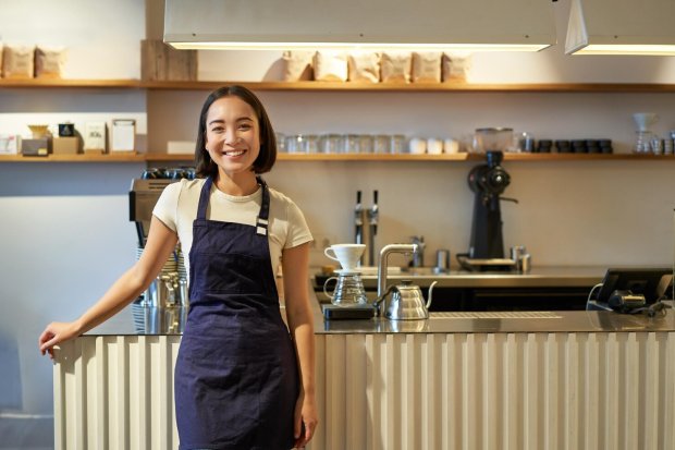 Mulher sorrindo com uma cozinha de fundo